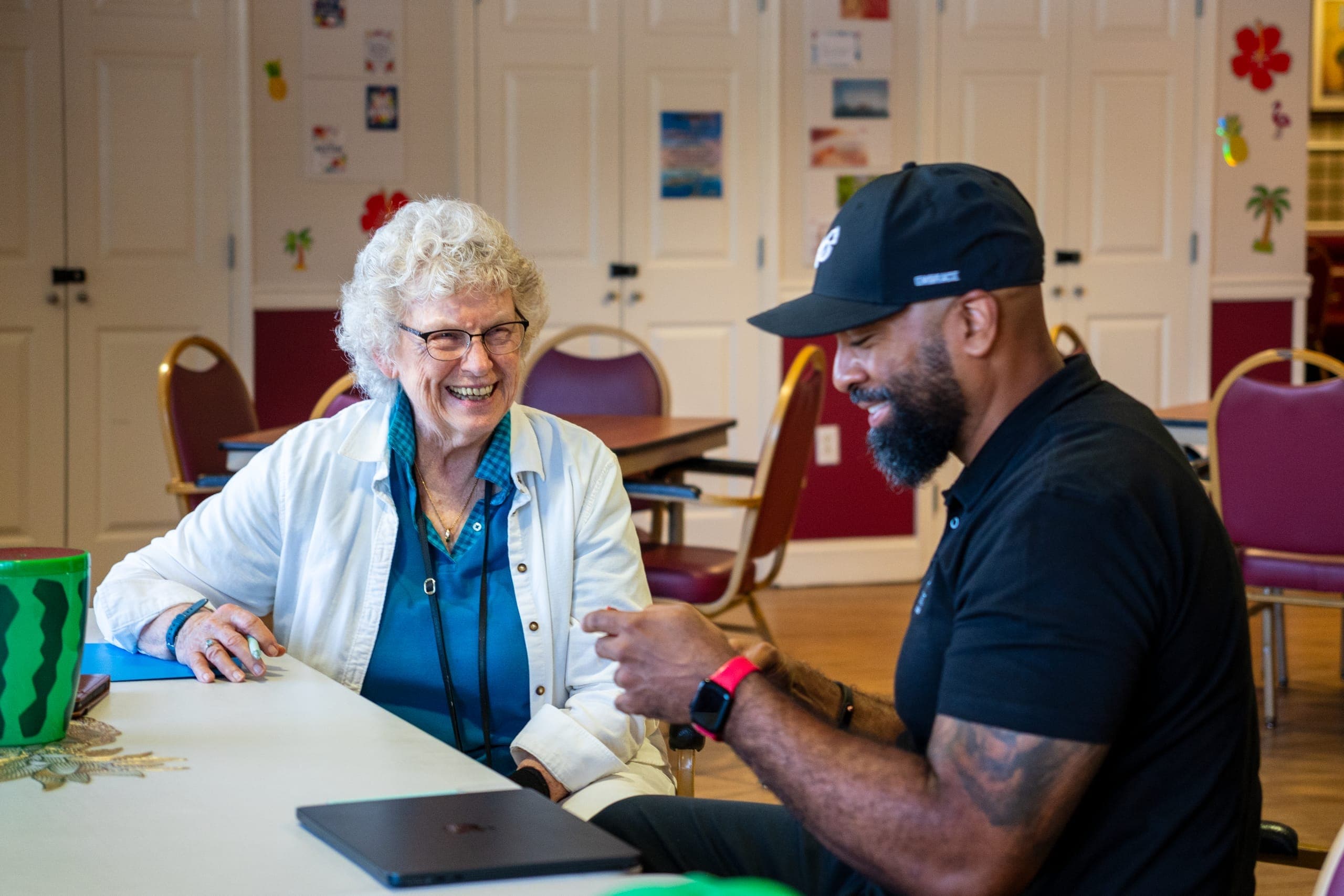 Senior Tech Care team member helping a resident with technology at a community workshop
