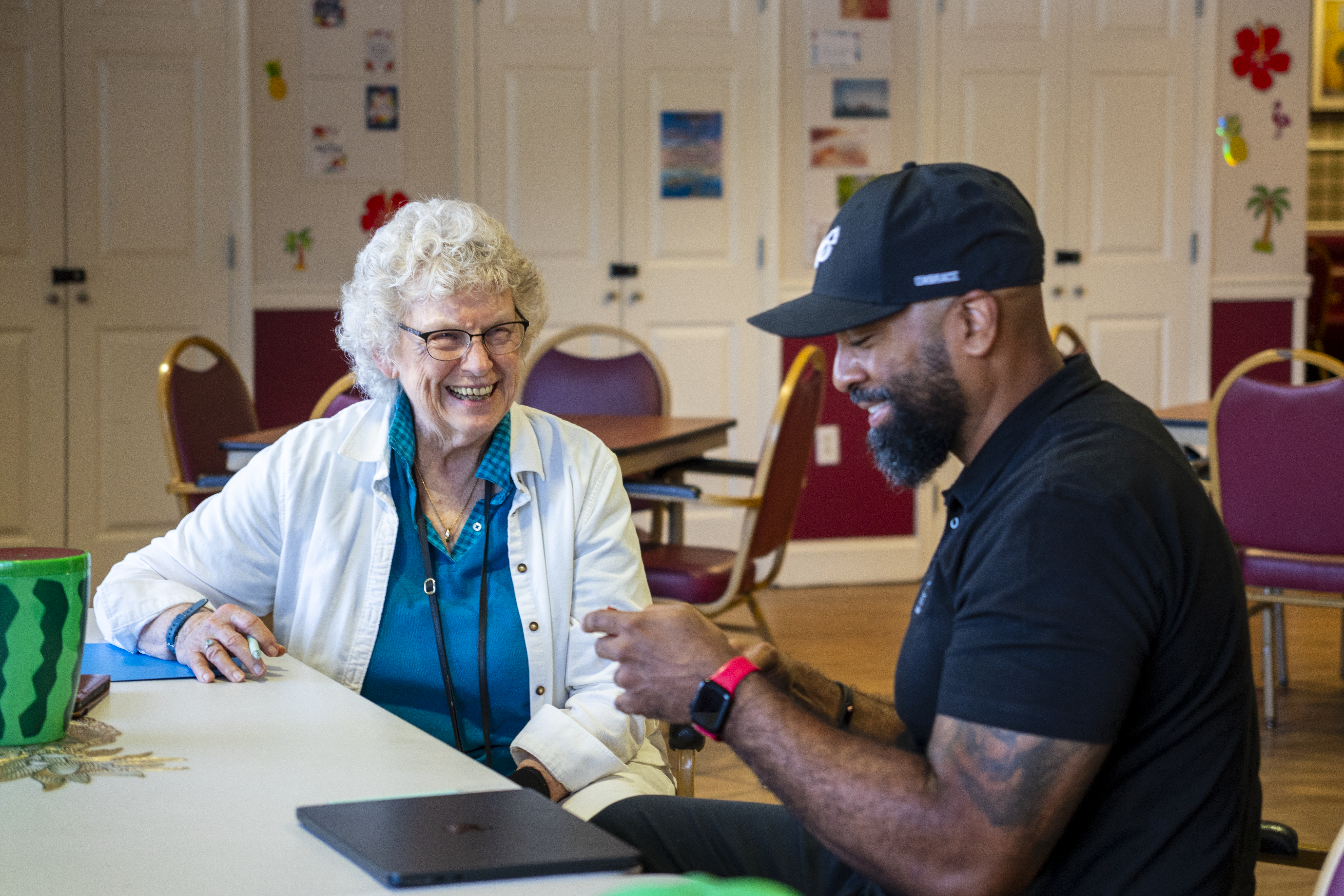 Senior Tech Care team member helping a resident with technology at a community workshop