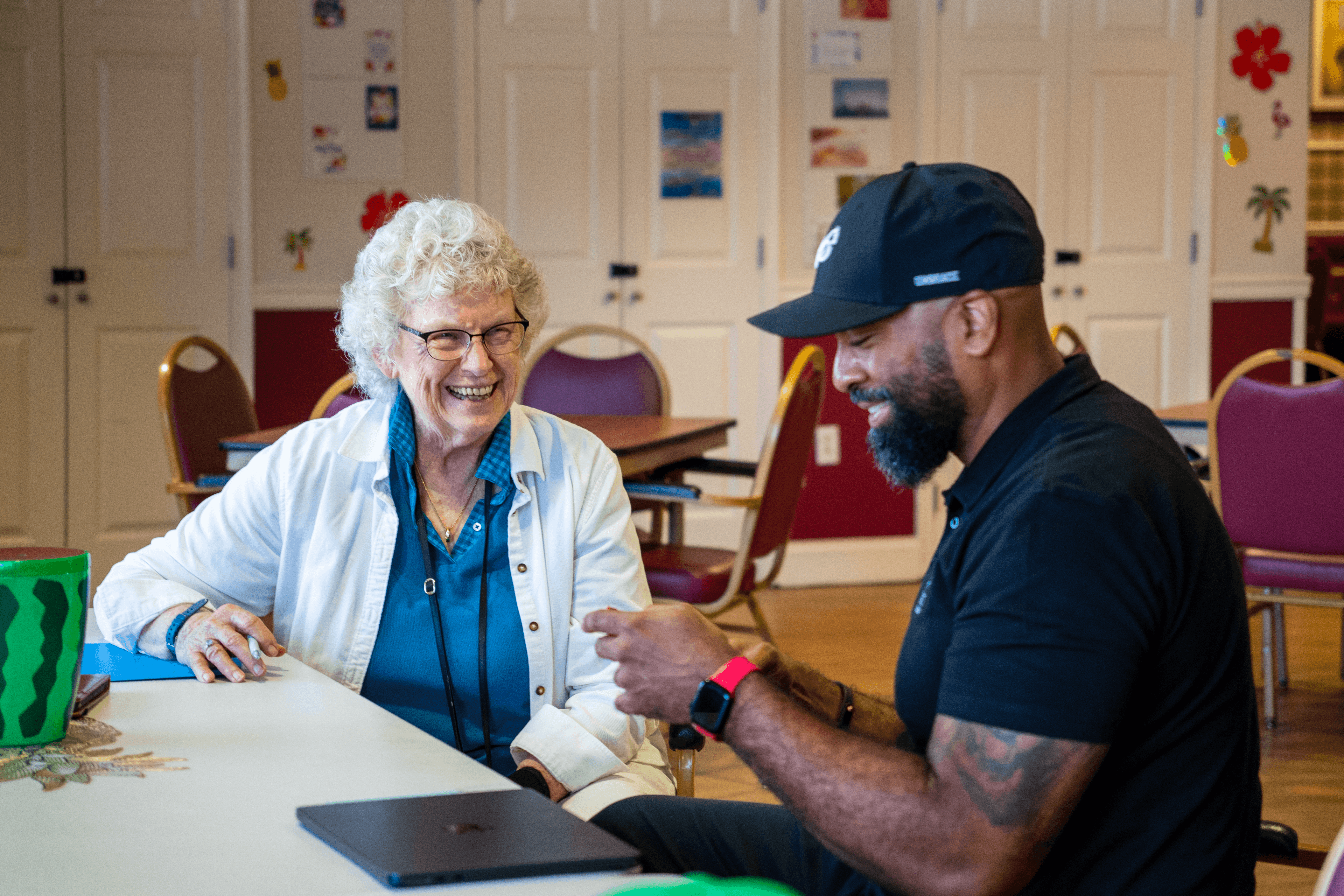 Senior Tech Care team member helping a resident with technology at a community workshop