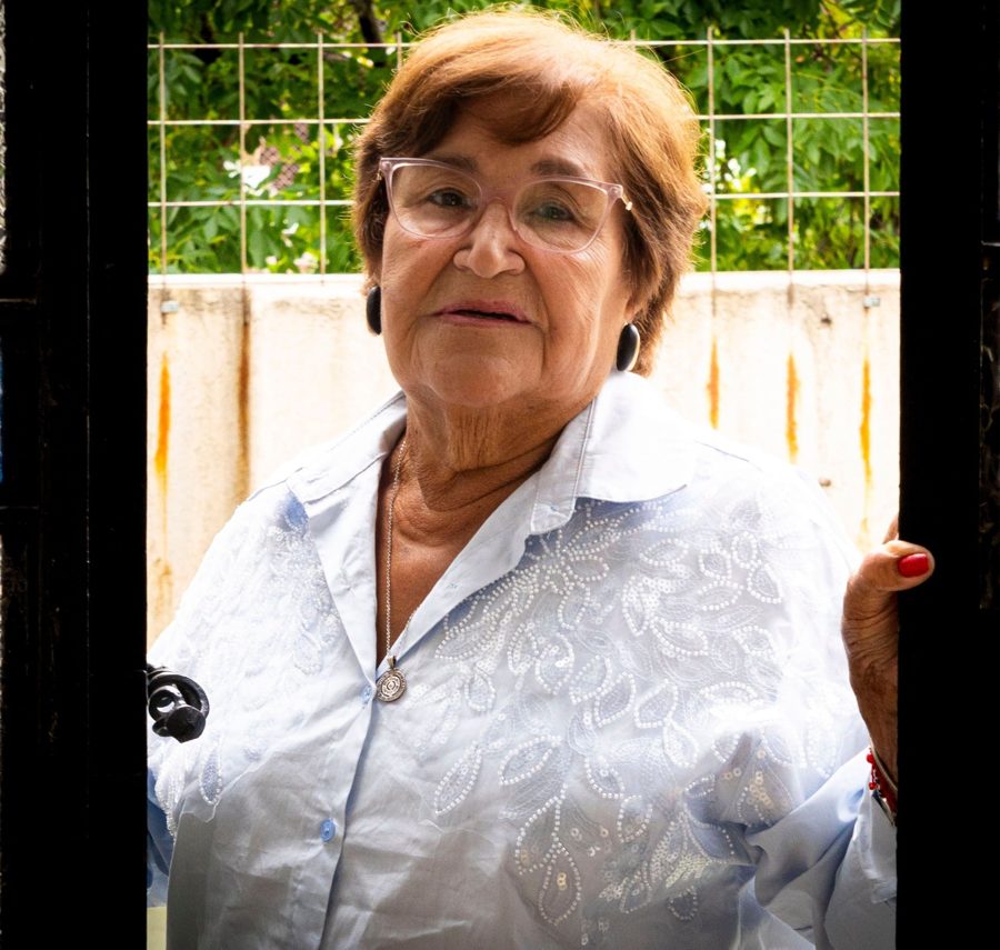 An older woman standing in her open front door